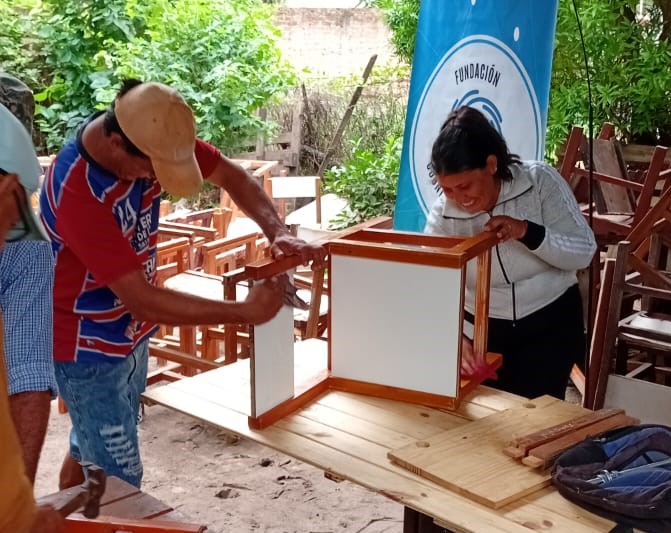 Jóvenes carpinteros y su labor en la recuperación de pupitres obsoletos